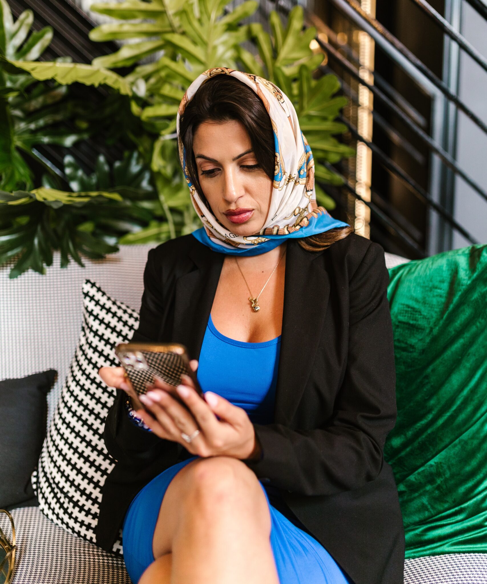 Woman in blue dress looking at a mobile phone in her hand