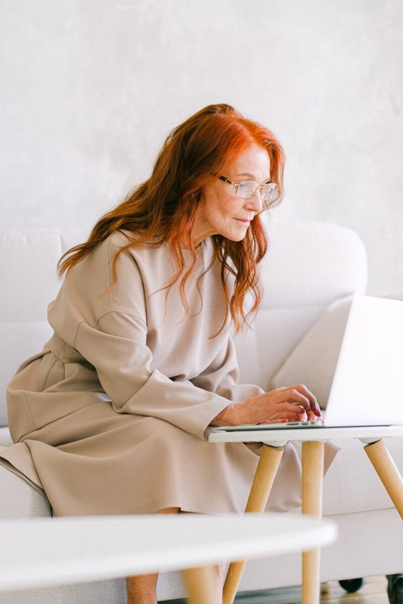 red headed woman working on laptop
